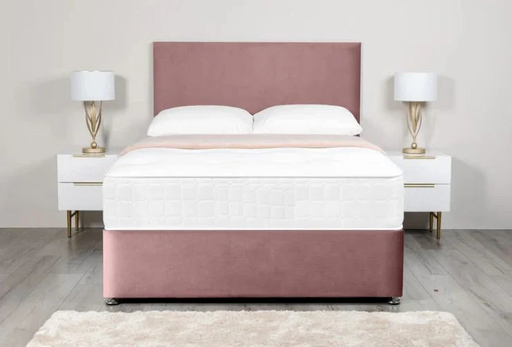 Pink upholstered bed with white bedding in a bedroom setting.