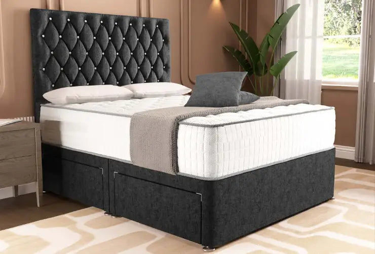 Black upholstered bed with white mattress and gray blanket in a room with curtains and plant.