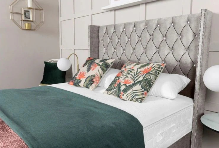 Bedroom with a bed featuring floral pillows and a textured headboard.