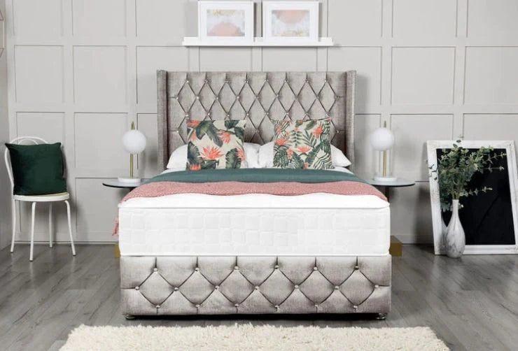 Bedroom with a tufted bed and decorative pillows against a gray paneled wall.