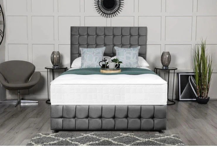 Gray upholstered bed in a modern bedroom setting with decor elements.