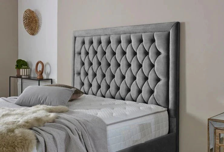 Gray upholstered bed with tufted design in a bedroom setting.