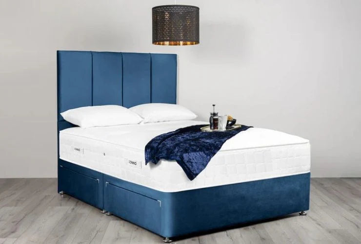 Blue upholstered bed with white bedding in a room setting.