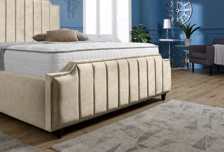 Beige upholstered bed in a bedroom setting with blue walls and a rug.
