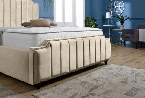 Beige upholstered bed in a bedroom setting with blue walls and a rug.